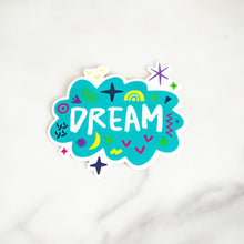 Load image into Gallery viewer, A vinyl die cut sticker with the word &quot;dream&quot; featured inside an illustrated cloud-shape with cute sketchy items around. 