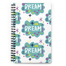 Load image into Gallery viewer, A spiral notebook is on a tabletop. The white spiral notebook has black spiral binding. The pattern design features the word &quot;dream&quot; inside a cloud shape with sketchy elements around. 