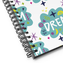 Load image into Gallery viewer, A close up of the spiral notebook binding. The pattern design features the word &quot;dream&quot; inside a cloud shape with sketchy elements around. 