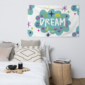 A large flag is featured hanging on the wall of a bedroom above a bed. The white flag features a pattern with the word "dream" featured inside a cloud with sketchy illustrations around the word. 