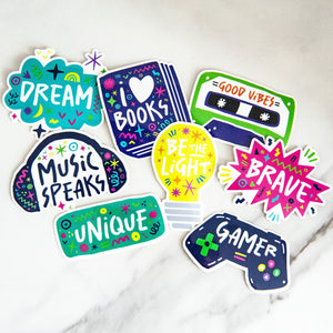 A pack of 8 vinyl, die-cut stickers featuring the words brave, unique, music speaks, good vibes, be the light, I love books.