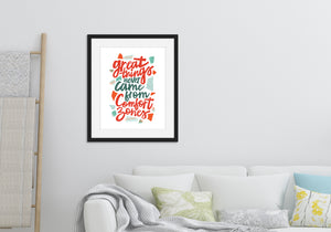 Lettering artwork is featured in a black frame above a sofa. The artwork features hand drawn lettering with the phrase "Great things never come from comfort zones."