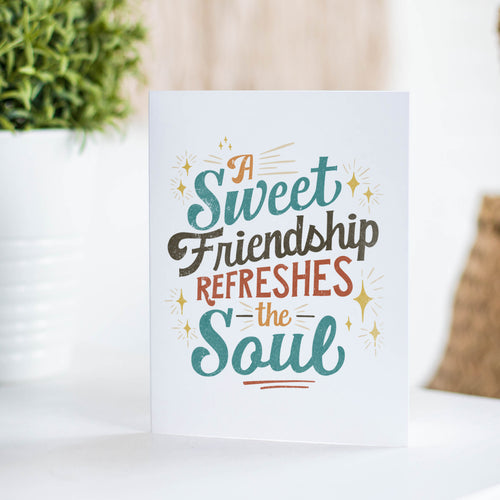 A white greeting card sitting on a a white table top with the words 