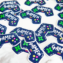 Load image into Gallery viewer, Vinyl die cut stickers with the word &quot;gamer&quot; inside an illustrated game contoller.