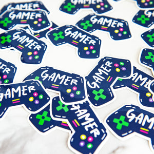 Vinyl die cut stickers with the word "gamer" inside an illustrated game contoller.