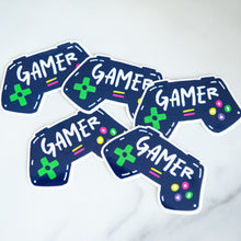 Load image into Gallery viewer, Vinyl die cut stickers with the word &quot;gamer&quot; inside an illustrated game contoller.