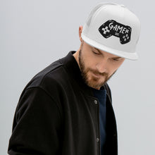 Load image into Gallery viewer, A man in a black shirt wearing a white trucker hat. The hat features an embroidered design with an illustrated game controller with the word &#39;gamer&#39; inside the illustration.  