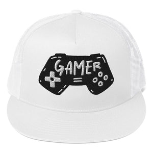 A white trucker hat on a white background showing a close up of the hat. The hat features an embroidered design with an illustrated game controller with the word 'gamer' inside the illustration.  