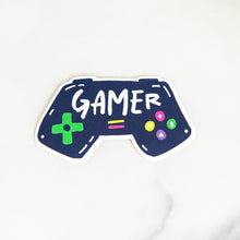 Load image into Gallery viewer, Vinyl die cut stickers with the word &quot;gamer&quot; inside an illustrated game contoller.