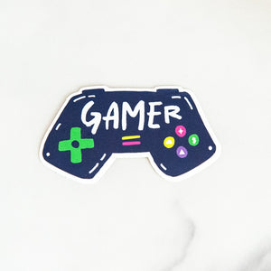 Vinyl die cut stickers with the word "gamer" inside an illustrated game contoller.