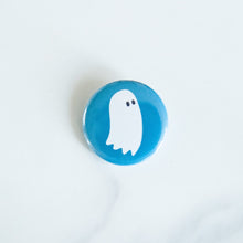 Load image into Gallery viewer, A button on a white tabletop. The button features an illustration of a ghost.