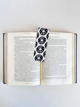 Load image into Gallery viewer, A bookmarks placed inside a book. The bookmark features the words &quot;good vibes&quot; inside an illustrated vinyl record.