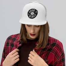 Load image into Gallery viewer, A woman in a red plaid shirt wearing a white trucker hat. The hat features an black embroidered design with an illustrated vinyl record and the words &#39;good vibes&#39; inside.  