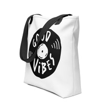 Load image into Gallery viewer, A side view of a white tote bag with black handles on a white background. The bag features a design with the words &#39;good vibes&#39; inside an illustrated vinyl record. 