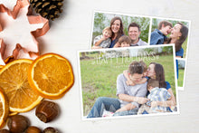 Load image into Gallery viewer, A photo of a Christmas card showing the front and back of the card laying on a white surface. Left of the card is a cookie cutter, pinecone, nuts and dried oranges. The front of the card features a photo and the words “Happy Holidays, The Thompsons” in a front font on top and the bottom of the card has whimsical illustrated pine trees. The back of the card features three photos with the illustrated trees on the bottom. 