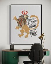 Load image into Gallery viewer, Artwork in a black frame with the with a white matte. The frame is hanging on a wall in an office above a desk. The artwork features an illustrated with the words &quot;Course He Isn&#39;t Safe, But He&#39;s Good. He&#39;s the King.&quot;