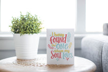 Load image into Gallery viewer, A greeting card laying on a wooden table with some cut wood details. The card features the words “I have found the one whom my soul loves.”