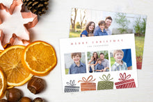 Load image into Gallery viewer, A photo of a Christmas card showing the front and back of the card laying on a white surface. Left of the card is a cookie cutter, pinecone, nuts and dried oranges. The front of the card features three photos with illustrated gifts on the bottom. On top of the photos the words “Merry Christmas” is featured with a family name below which you can edit. The back of the card features one photo with some more illustrated gifts. 