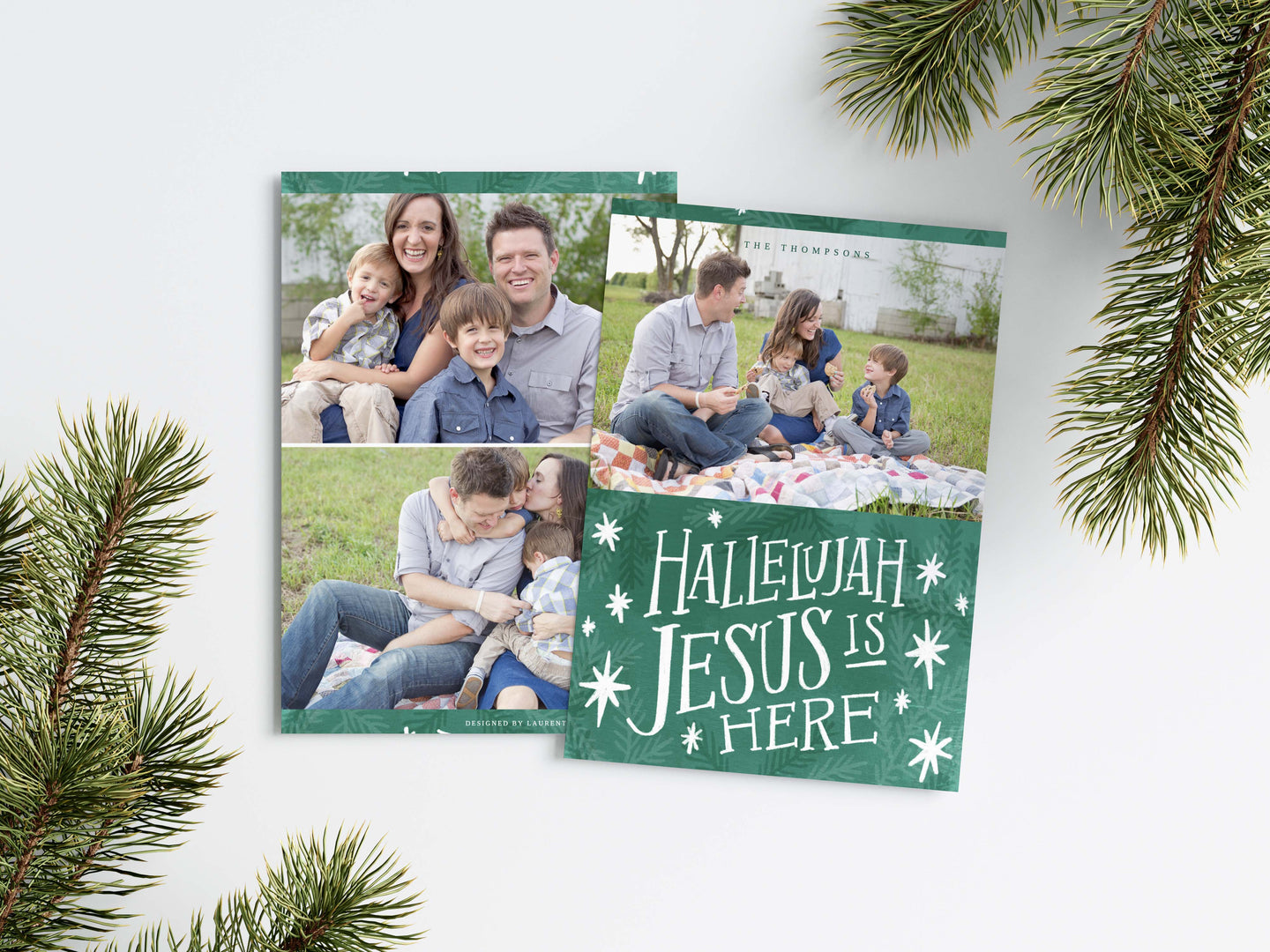 A photo of a Christmas card showing the front and back of the card laying on a white surface. Around the two sides of the card are pine needles. The front of the card features a photo on the top and on the bottom is in green with words in white “Hallelujah Jesus is Here” with white stars around it. The back of the card features two photos. 