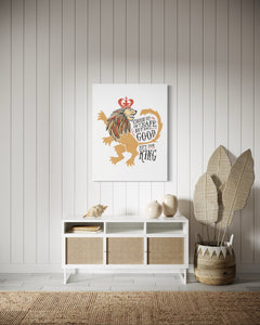 A white canvas with artwork hanging on a wall above a a credenza in an entryway. The artwork features an illustrated lion with a crown and reads "Course He Isn't Safe, But He's Good. He's the King."