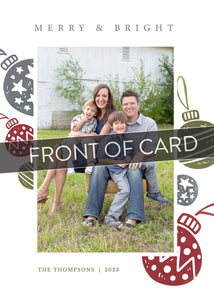 A close up of the front of the card showing the front of the card design. Across the image is a gray strip with the words “front of card” on it. The front of the card features a photo with the words Merry & Bright at the top and illustrated ornaments around the photo. 