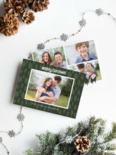 Load image into Gallery viewer, A photo of a double-sided Christmas card showing the front and back of the card laying on a white surface. Around the two sides of the card are pine cones, pine needles and a string of silver snowflake garland. The front of the card features a photo with a frame around it with illustrated pine trees. Above the photo reads “Merry Christmas” and below the photo you can add your family name. The back of the card features three photos with illustrated pine trees. 