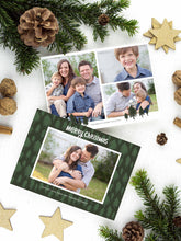 Load image into Gallery viewer, A photo of a two-sided Christmas card showing the front of the card on top of a brown wrapped gift on a white tabletop. Around the gift are pine needles, pinecones and wood star ornaments. The front of the card features a photo with a frame around it with illustrated pine trees. Above the photo reads “Merry Christmas” and below the photo you can add your family name. The back of the card features three photos with illustrated pine trees. 