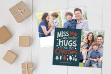 Load image into Gallery viewer, A photo of a Christmas card showing the front and back of the card laying on a white surface. Brown wrapped small gifts are to the left of the cards. The front of the card features a photo on the right side and on the left side are the words “ Miss you and sending hugs to you this Christmas” with illustrated trees below the words. The back of the card features two photos with illustrated trees at the bottom.