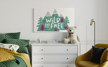 Load image into Gallery viewer, A large white flag featured on a wall of a bedroom above a dresser. The white flag features the words &#39;wild and free&#39; inside illustrated mountains with sketch trees and other elements around.