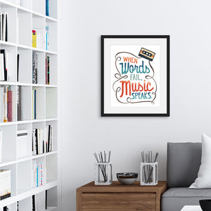 Artwork featured on a wall in a black frame by a shelving unit. The artwork features hand drawn lettering with the phrase "When words fail, music speaks." In the upper corner of the words an illustrated cassette tape is featured.