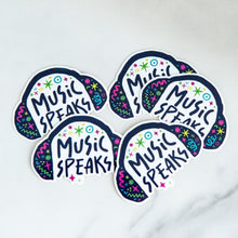 Load image into Gallery viewer, Vinyl die cut stickers with the words &quot;music speaks&quot; with illustrated headphones around the words. 