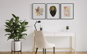 A set of three artwork prints hanging on a wall above a desk. The artwork is inspired by the Chronicles of Narnia. The first print reads "Course He Isn't Safe, But He's Good. He's the King." The second print reads "At The Sound of Your Roar, Sorrows Will Be No More," and the last print reads "Once a king or queen of Narnia, always a king or queen of Narnia."