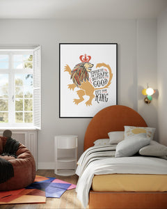 Artwork in a black frame with the with a white matte. The frame is hanging on a wall in a kid's bedroom. The artwork features an illustrated with the words "Course He Isn't Safe, But He's Good. He's the King."