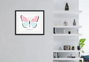 Artwork featured on a wall in a black frame by a shelving unit. The hand drawn artwork features the scripture verse "Therefore, if anyone is in Christ, the new creation has come. The old has gone. The new is here." The words are featured inside a butterfly. 