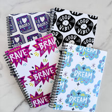 Load image into Gallery viewer, A set of four spiral bound notebooks. The notebooks feature a pattern design  with the words brave, dream, good vibes and I love books. 