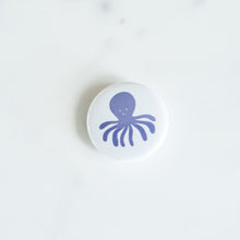 Load image into Gallery viewer, A button on a white tabletop. The button features an illustration of an octopus. 