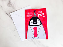 Load image into Gallery viewer, A greeting card laying on a table with the envelope. The card features an illustrated penguin with a party hat on and holding the number one and reads &quot;Happy birthday little one.&quot;