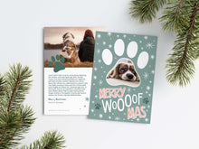 Load image into Gallery viewer, A photo of a Christmas card showing the front and back of the card laying on a white surface. Around the two sides of the card are pine needles. The front of the card features a photo inside a paw shaped frame. Around the photo are white stars and below are the words “Merry Woofmas.” The back of the card features one photo with a dog paw illustration and space to add an update. 