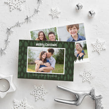 Load image into Gallery viewer, A photo of a double-sided Christmas card showing the front and back of the card laying on a white surface. Around the two sides of the card are surrounded with Christmas items. The front of the card features a photo with a frame around it with illustrated pine trees. Above the photo reads “Merry Christmas” and below the photo you can add your family name. The back of the card features three photos with illustrated pine trees.