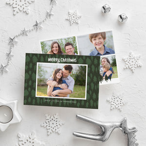 A photo of a double-sided Christmas card showing the front and back of the card laying on a white surface. Around the two sides of the card are surrounded with Christmas items. The front of the card features a photo with a frame around it with illustrated pine trees. Above the photo reads “Merry Christmas” and below the photo you can add your family name. The back of the card features three photos with illustrated pine trees.