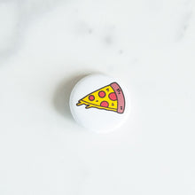 Load image into Gallery viewer, A button pin on a white tabletop. The pin features an illustration of a slice of pizza.