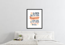 Load image into Gallery viewer, Artwork is featured in a black frame on a white wall above a bed with white linens. The artwork features hand drawn lettering of the Bible verse Numbers 6:24-26 reading &quot;The Lord bless you and keep you. The Lord make his face to shine on you and be gracious to you. The Lord turn his face toward you and give you peace.&quot;
