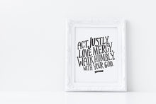 Load image into Gallery viewer, Artwork in a white frame with the with a white matte. The frame is leaning on a white counter. The artwork features hand drawn lettering reading &quot;Act Justly, Love Mercy, Walk Humbly with your God&quot; - Micah 6:8.