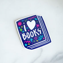 Load image into Gallery viewer, A vinyl die cut sticker featuring the words &quot;I Love Books&quot; inside an illustrated book. 