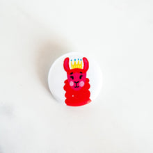 Load image into Gallery viewer, A buttons on a white tabletop. The button features a red illustrated llama with crown on. 