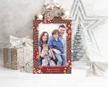 Load image into Gallery viewer, A photo of a one-sided Christmas card showing the front of the card standing up with Christmas items behind the card. There’s a sparkly star, glitter wrapped gift, ribbon and ornaments with a small silver tree around the photo card. The photo card features one photo with a frame of illustrated leaves in various colors. Below the photo it reads “Rejoice Greatly” and has space to put your family name. 