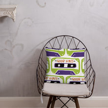 Load image into Gallery viewer, A white pillow on a metal chair. The white pillow features the artwork on a white background with an illustrated cassette tape pattern with the words &#39;good vibes.&#39;