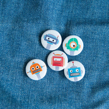 Load image into Gallery viewer, A set of five button pins on a jean jacket. The buttons feature five different illustrations of robots.