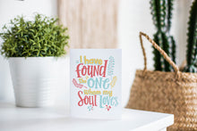 Load image into Gallery viewer, A greeting card is featured on a white tabletop with a white planter in the background with a green plant. There’s a woven basket in the background with a cactus inside. The card features the words “I have found the one whom my soul loves.”