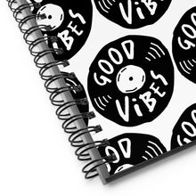 Load image into Gallery viewer, A close up of the spiral notebook binding. The pattern design features the words &quot;good vibes&quot; inside an illustrated vinyl record.  